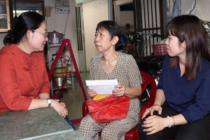 第八郡黨員向古氏深（中）問候和贈送輔助金。