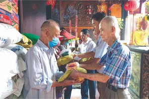 福建霞漳會館理事送米給貧困者。　　心雨　攝