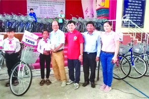 　　溫陵會館理事與第五郡紅十字會代表贈送 自行車給貧困學生。