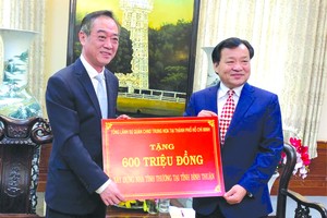 中國駐本市總領事吳駿(左)向平順省 人委會主席阮文二移交捐款。