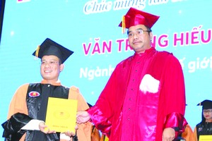 華人幹部文忠孝(左)接受頒發博士學位證書。