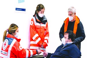 德國埃森展覽館的新冠疫苗接種中心工作人員為訪客進行登記。