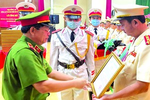 市公安廳副廳長給阮煌勝大校頒授《決定》。