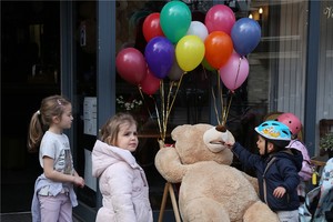 孩子們被法國巴黎街頭一家餐館外的玩具熊吸引。