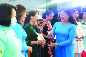 第五郡勞動聯團主席黎氏碧幸向女職工 頒發模範獎。