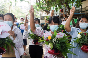 緬甸婦女在仰光手捧鮮花參加反對軍事政變的抗議活動。（圖源：互聯網） 