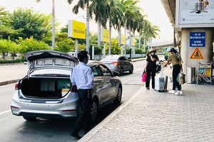 乘客在新山一機場國際航站樓B車道搭乘網約車。 