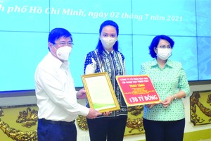 萬盛發集團總經理張惠雲(中)向市人委會主席阮成鋒和市越南祖國陣線委員會主席蘇氏碧珠遞交1300億元善款。