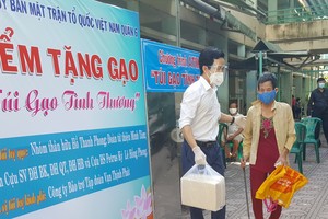 第六郡越南祖國陣線委員會主席阮國洋向貧困者贈送大米。