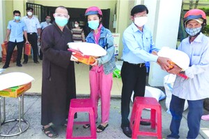 釋玄雄法師與平新郡平治東A坊人委會主席何英俊向貧困者贈送禮物。