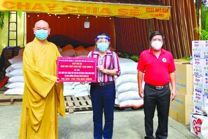 　　范氏明月副主席接受郡佛教會會長 釋慧功法師轉交的物資。