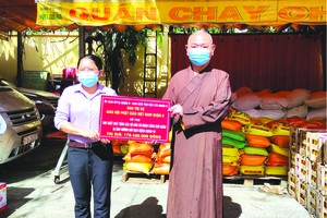 　　釋慧功法師向第八郡祖國陣線委員會副主席 范氏明月轉贈救濟物資。