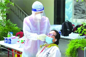 醫護人員為準備返鄉避疫大學生做採檢。