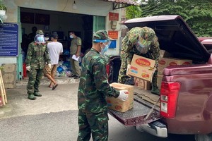 部隊力量把準備供應給民眾的食品、蔬菜裝上車。