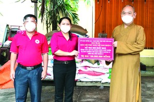 釋慧功法師向范氏明月副主席轉交物資。