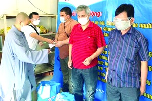 妙法寺住持釋宏心法師向視障者贈送救濟品。