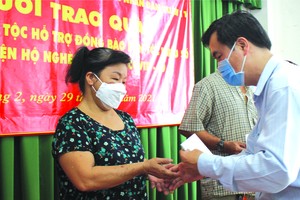 市民族處副主任曾福祿向感染新冠肺炎病 毒的華人同胞贈送資助金。