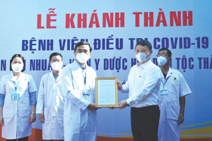 　　市人委會副主席楊英德(右)向富潤郡 新冠病例收治醫院頒授成立《決定》。