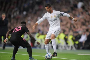 Cristiano Ronaldo (phải, Real Madrid) rê bóng trước hậu vệ PSG. Ảnh: Getty Images.