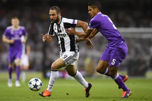 Gonzalo Higuain (trái, Real Madrid) đi bóng qua hậu vệ Raphael Varane (Real Madrid)