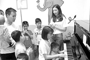 歌手黎玄英（坐者）與2016越南小姐 杜美玲於4月2日中午，在中央血液學與輸血院同病童邊彈邊唱。