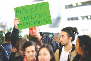 示威者在芝加哥機場高舉標語抗議。