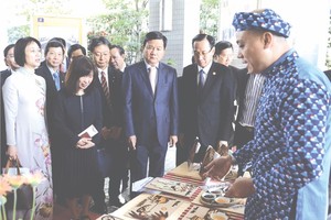 本市高級代表團參觀用大米作畫展位。