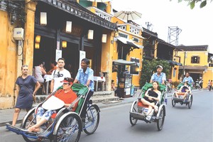 國際遊客乘坐三輪車參觀會安古埠。