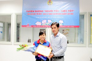 何氏七接受市勞動聯團代表頒發的獎狀和紀念品。（圖源：SGGP）