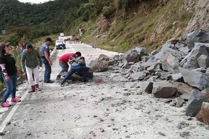 022年7月27日，菲律宾科迪勒拉，当地发生地震后引发山体滑坡，村民清理道路。