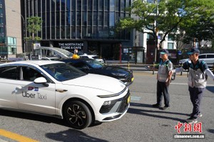 当地时间8月22日下午，工作人员在首尔明洞地铁站附近开展针对出租车不良营运行为的整治行动。