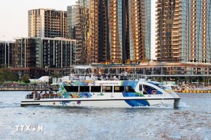 游客乘船在西贡河上参观胡志明市。