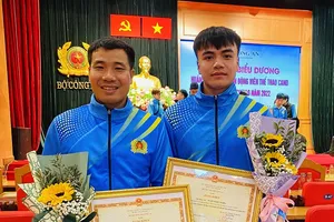 Ngần Ngọc Nghĩa (phải) và HLV của mình tại buổi lễ tuyên dương. Ảnh: MINH CHIẾN