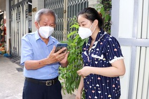 Nguyen Vinh Ngoc, leader of Neighborhood 23 in Ward 4 of District 4, is answering questions of neighborhood members regarding the eligible list to obtain financial support in the third round. (Photo: SGGP)