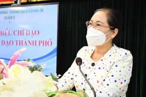 Chairwoman of HCMC People’s Council Nguyen Thi Le is distributing the certificate of contribution to various local teams and organizations for their devotion to Covid-19 fight. (Photo: SGGP)