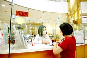 Making a transaction in a bank in HCMC. (Photo: SGGP)
