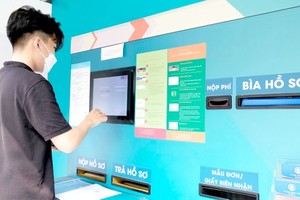 Duong Gia Huy from District 6 is submitting necessary documents for administrative procedures via the automatic document receipt system. (Photo: SGGP)