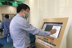 Citizens check the progress of online public services at the People’s Committee of Hoc Mon District in HCMC