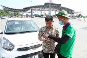 The staff on Phap Van – Cau Gie Expressway is helping vehicle drivers to open a traffic account and install an ETC card onto the vehicle. (Photo: SGGP)