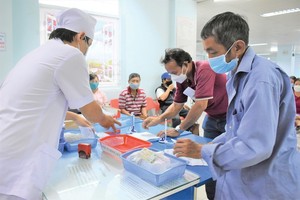 Outpatients of Binh Thanh District Hospital are receiving medicine under health insurance.