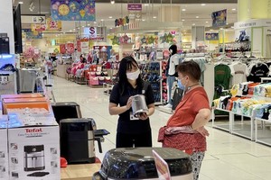 Customers are learning about household products in a supermarket in HCMC. (Photo: SGGP)