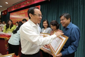 Secretary of HCMC Party Committee Nguyen Van Nen is giving merit certificates to collectives with excellent achievements in internal affairs tasks in 2022. (Photo: SGGP)