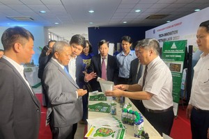 Minister of Technology and Communications of Laos Boviengkham Vongdara and Deputy Minister of Science and Technology Tran Van Tung are visiting the booth displaying products and technologies of the Institute of Technology Application (Photo: Ministry of Science-Technology)