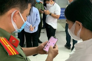 A police officer is instructing a citizen to carry out an online public service (Photo: SGGP)