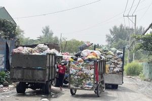 An outdated garbage collection vehicle is working at a waste gathering point in Long Truong Ward of Thu Duc City (Photo: SGGP)