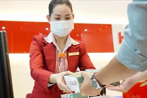 A customer is making a transaction in a bank in District 1, HCMC (Photo: SGGP)