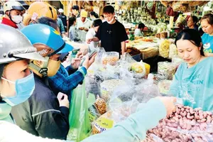 Customers are buying cashew and other dried food in Binh Tay Market on January 28 (Photo: SGGP)