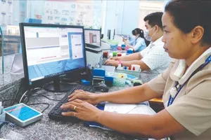 Civil servants in An Phu Dong Ward of District 12 are processing documents for administrative procedures (Photo: SGGP)