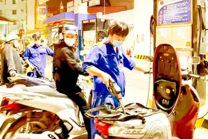 Employees of Petrolimex No.4 Fuel Station (on Nguyen Trai Street of District 5, HCMC) are serving customers (Photo: SGGP)