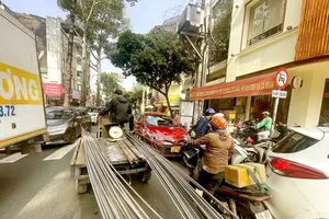 A three-wheeled vehicle carrying oversized goods at the Cao Thang - Vo Van Tan Intersection (District 3, HCMC) is dangerous for traffic participants (Photo: SGGP)